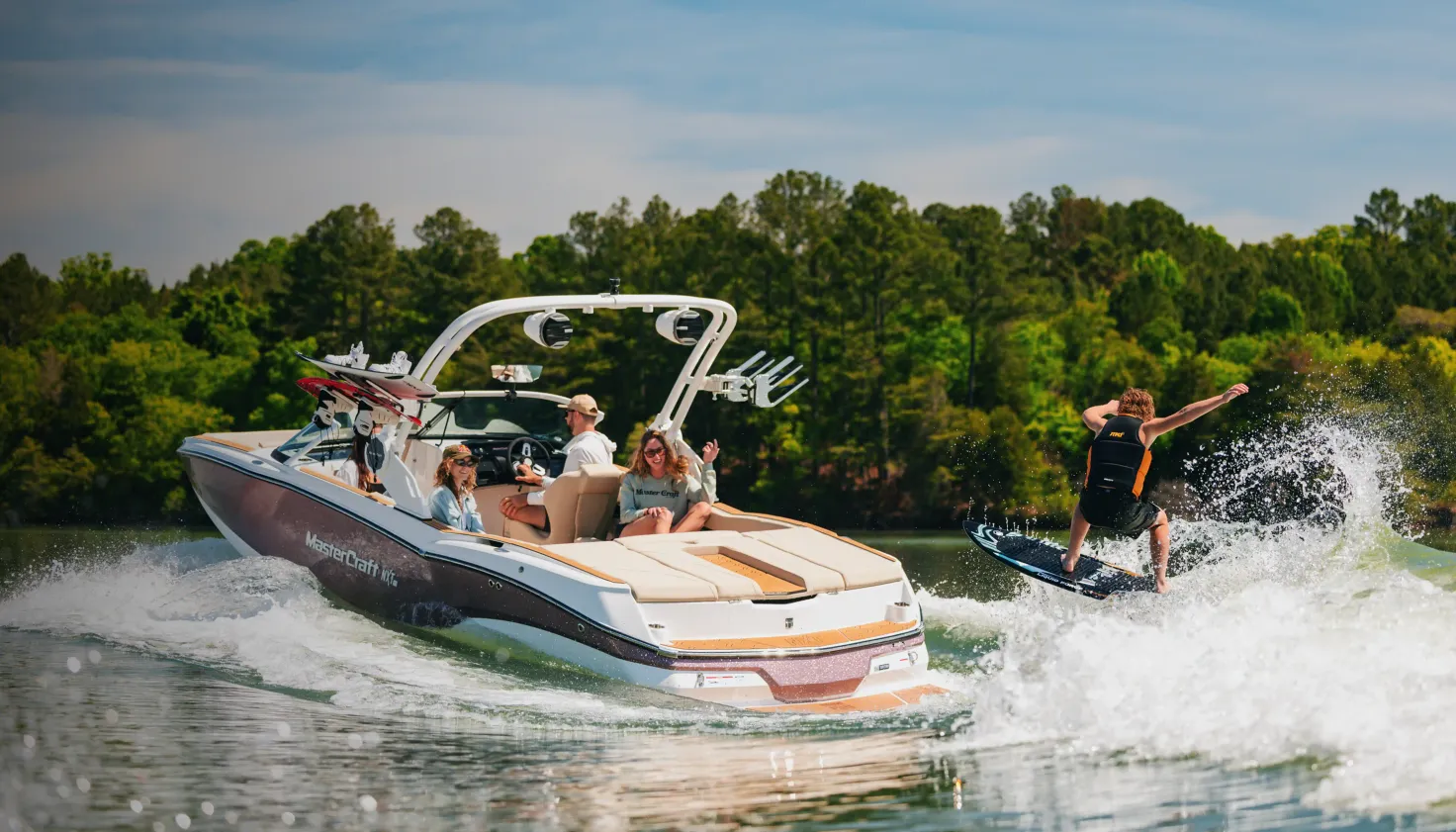 Wakesurfeur derrière un MasterCraft NXT avec sa famille à bord